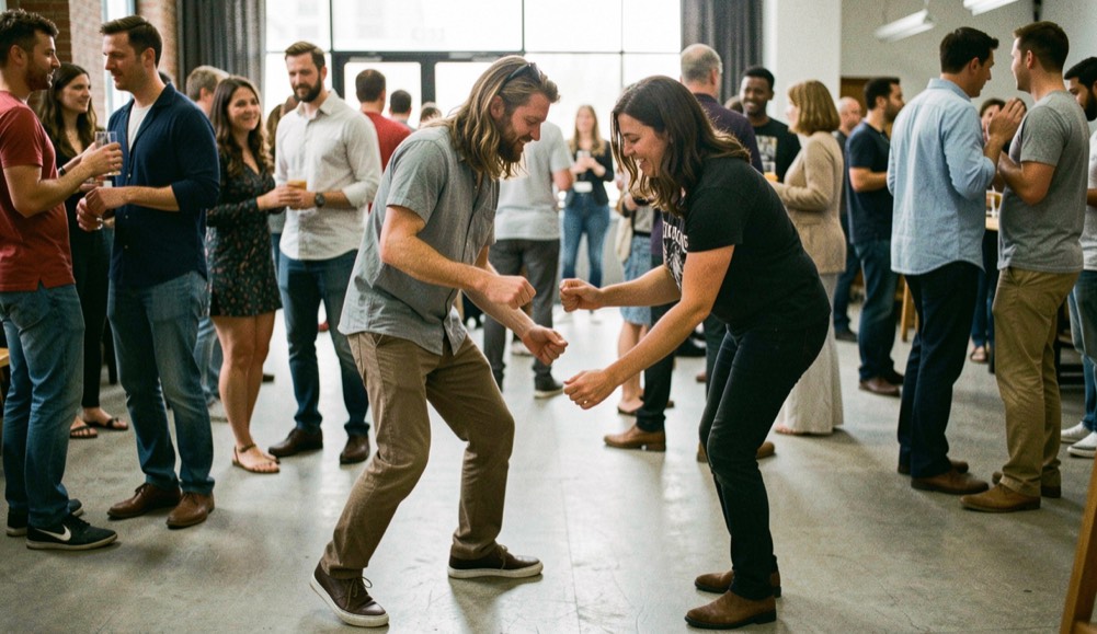 A lead and follow practise a small six-count bop pattern with relaxed posture on a busy social floor.